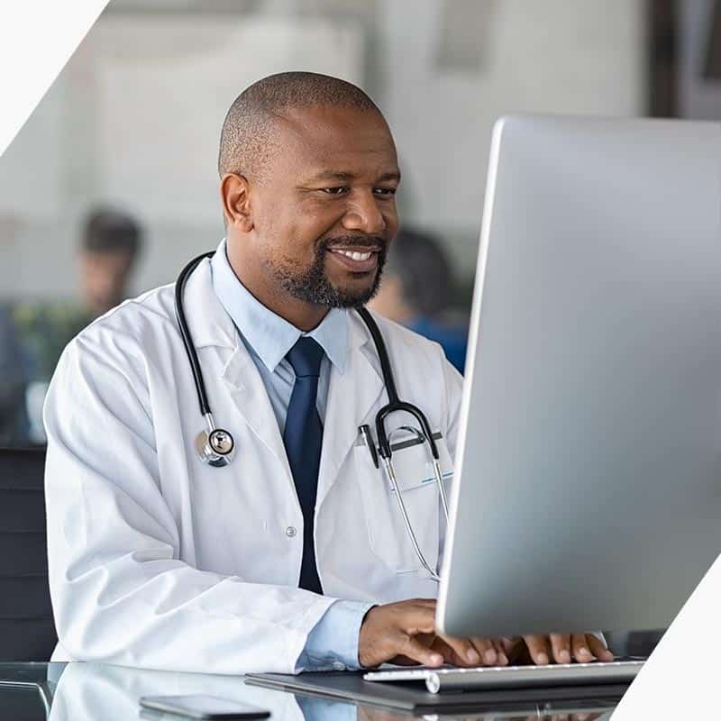 Doctor smiling while working on a computer