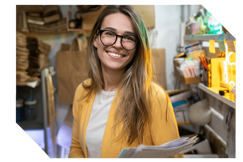 successful small business owner in casual wearing yellow cardigan standing in her store